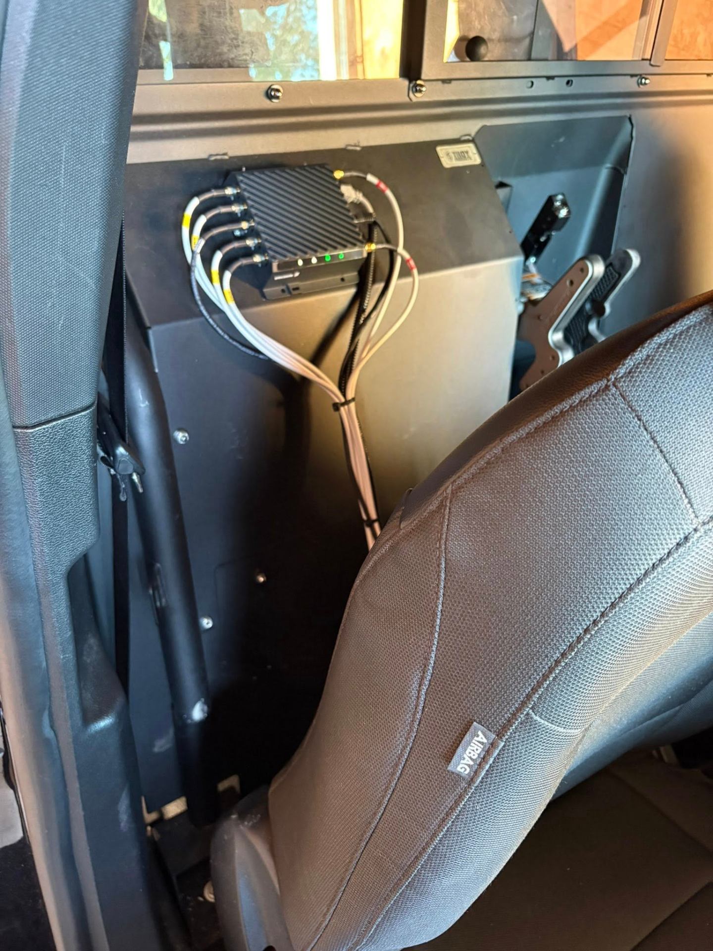 Cradlepoint router and cabling mounted behind the front seat partition