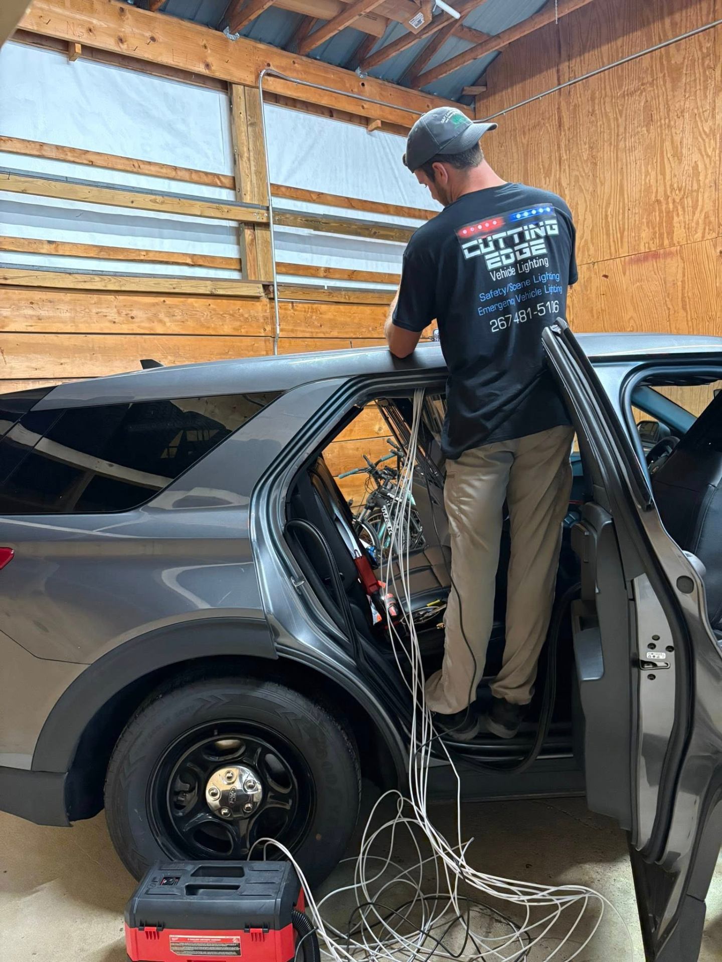 CuttingEdge technician routing 5G antenna cabling inside an Upper Perk police interceptor
